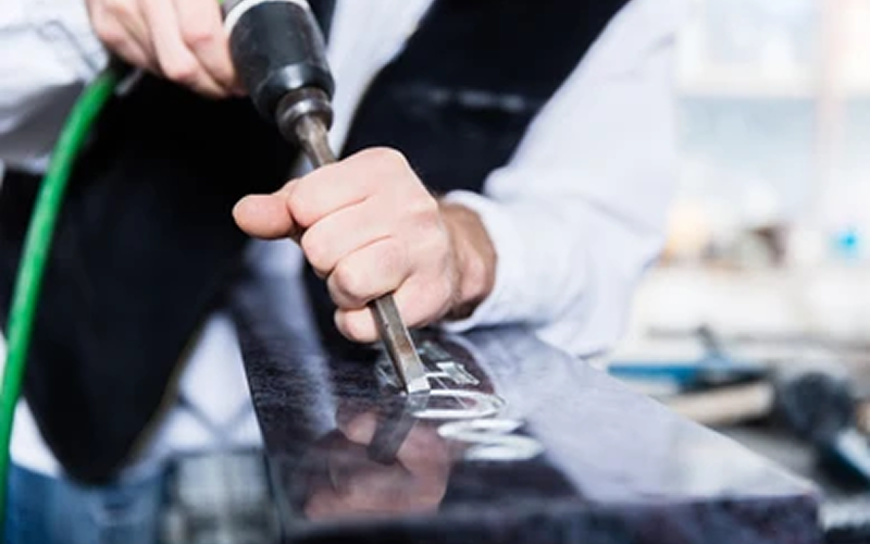 craftsman working on headstone engraving